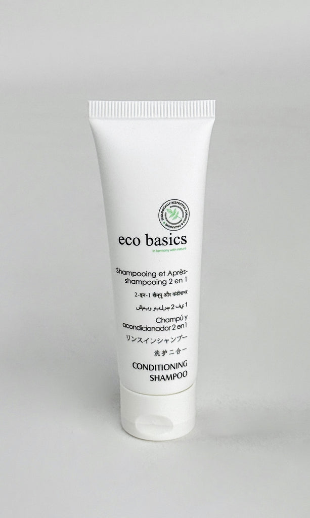 A white squeeze tube of eco basics Conditioning Shampoo, featuring black text and a small green leaf logo, set against a neutral light gray background.